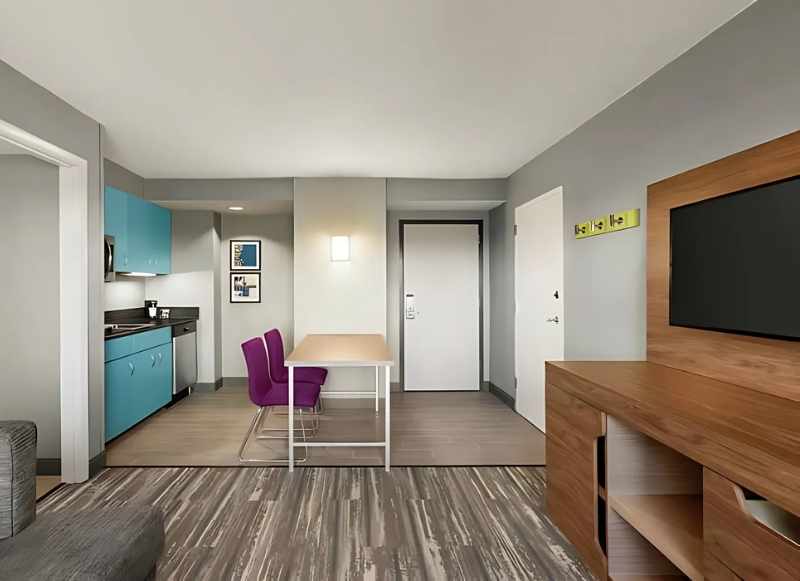A modern hotel room featuring a kitchen and a couch, designed for comfort extended stay hotel Fort Lauderdale.