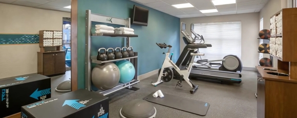 Exercise equipment and a television in the gym room of Extended Stay Hotel Fort Lauderdale, promoting fitness for guests.