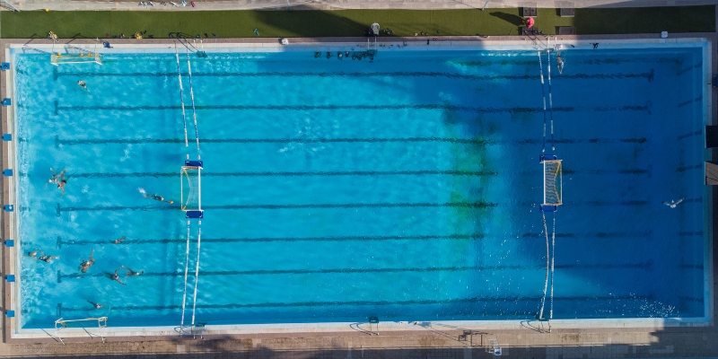 Aerial view of a swimming pool at the Fort Lauderdale Aquatic Complex, showcasing its vibrant blue water and surrounding area.