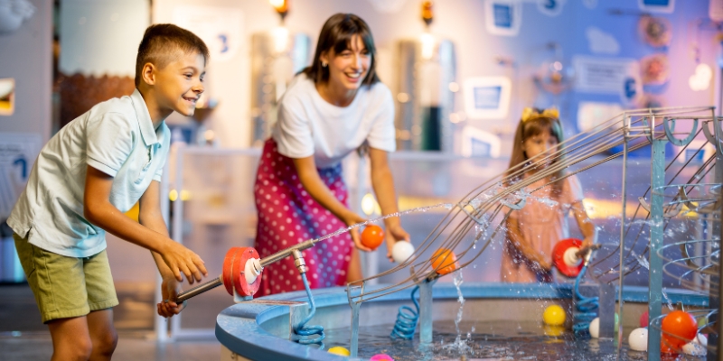 A family engages with water toys in an interactive exhibit at the Museum of Discovery and Science in Fort Lauderdale.