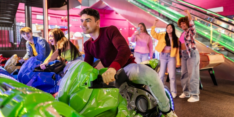 A cheerful group of individuals experiencing virtual racing at Xtreme Action Park, a popular family attraction in Fort Lauderdale.