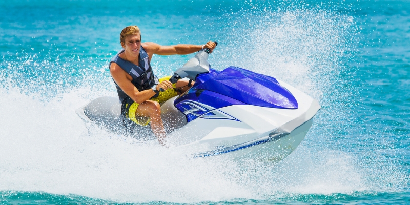 A man rides a jet ski in the ocean, illustrating the thrill of water activities in Fort Lauderdale's beach environment.