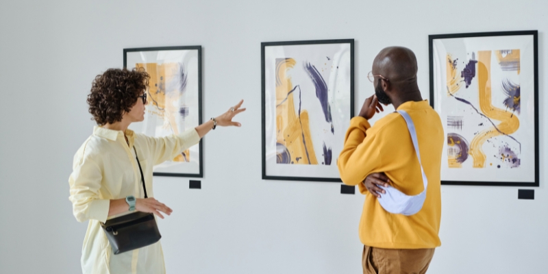 Two people engage with art in a gallery, showcasing the cultural experience of winter in Fort Lauderdale.
