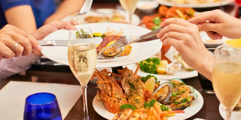 A group of people enjoying a seafood feast at a restaurant in Fort Lauderdale, showcasing local cuisine and festive atmosphere.